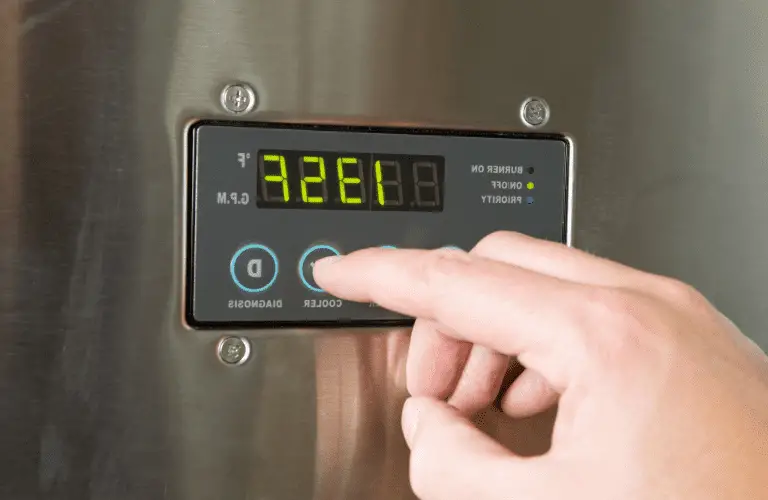 man finger turning down tankless water heater temperature